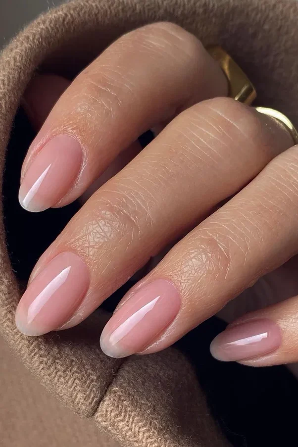 A minimalist manicure featuring natural gloss over healthy nails, representing quiet luxury.