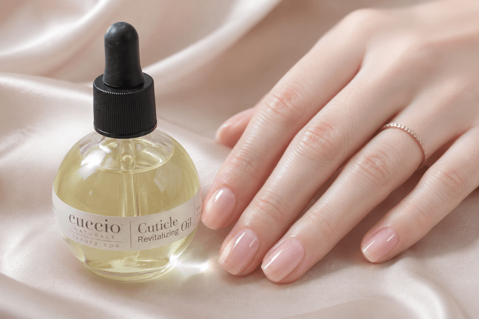 High-quality cuticle oil bottle next to a hand to illustrate how to keep nails looking fresh between salon visits through hydration.
