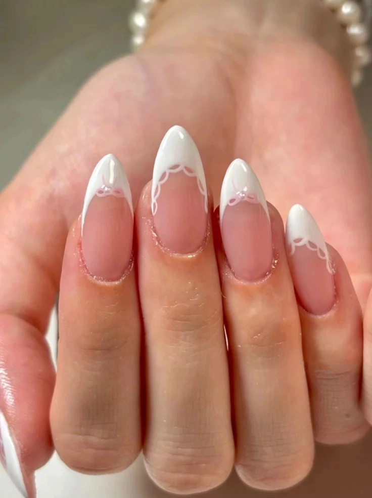 Sophisticated white lace detailing on tips, a refined soft pink nail style.