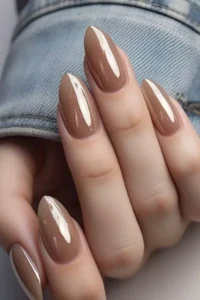 Elegant and youthful glossy almond-shaped nails in milky brown.