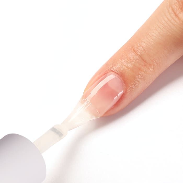 Applying a strengthening top coat to protect fragile nails during the nail strengthening process