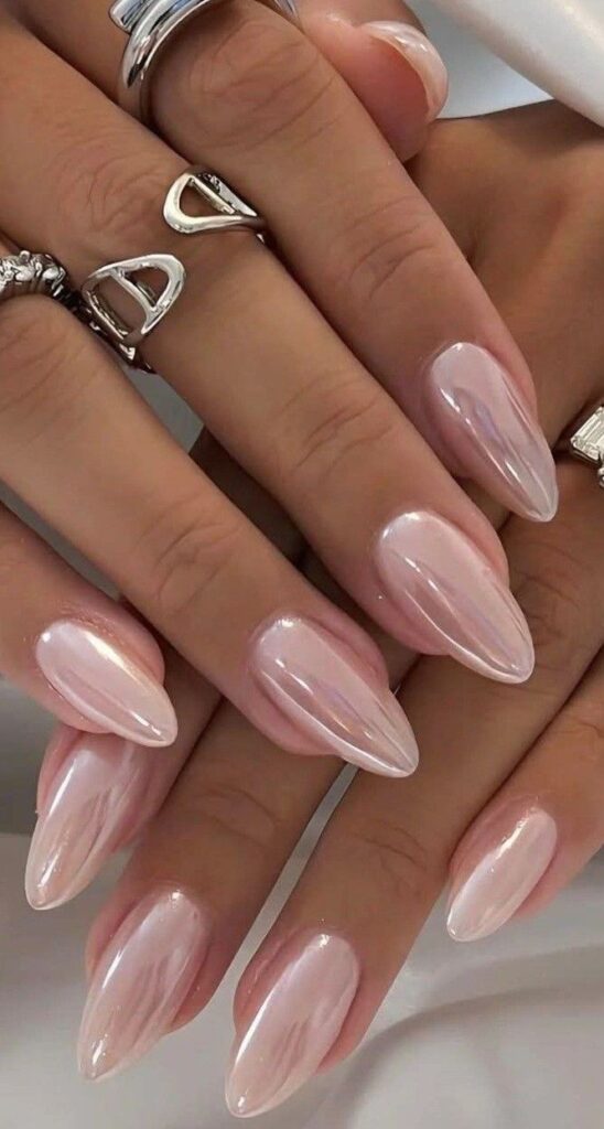 Champagne shimmer sheer pink almond nails with a luminous pearly glow perfect for a classy feminine nail look
