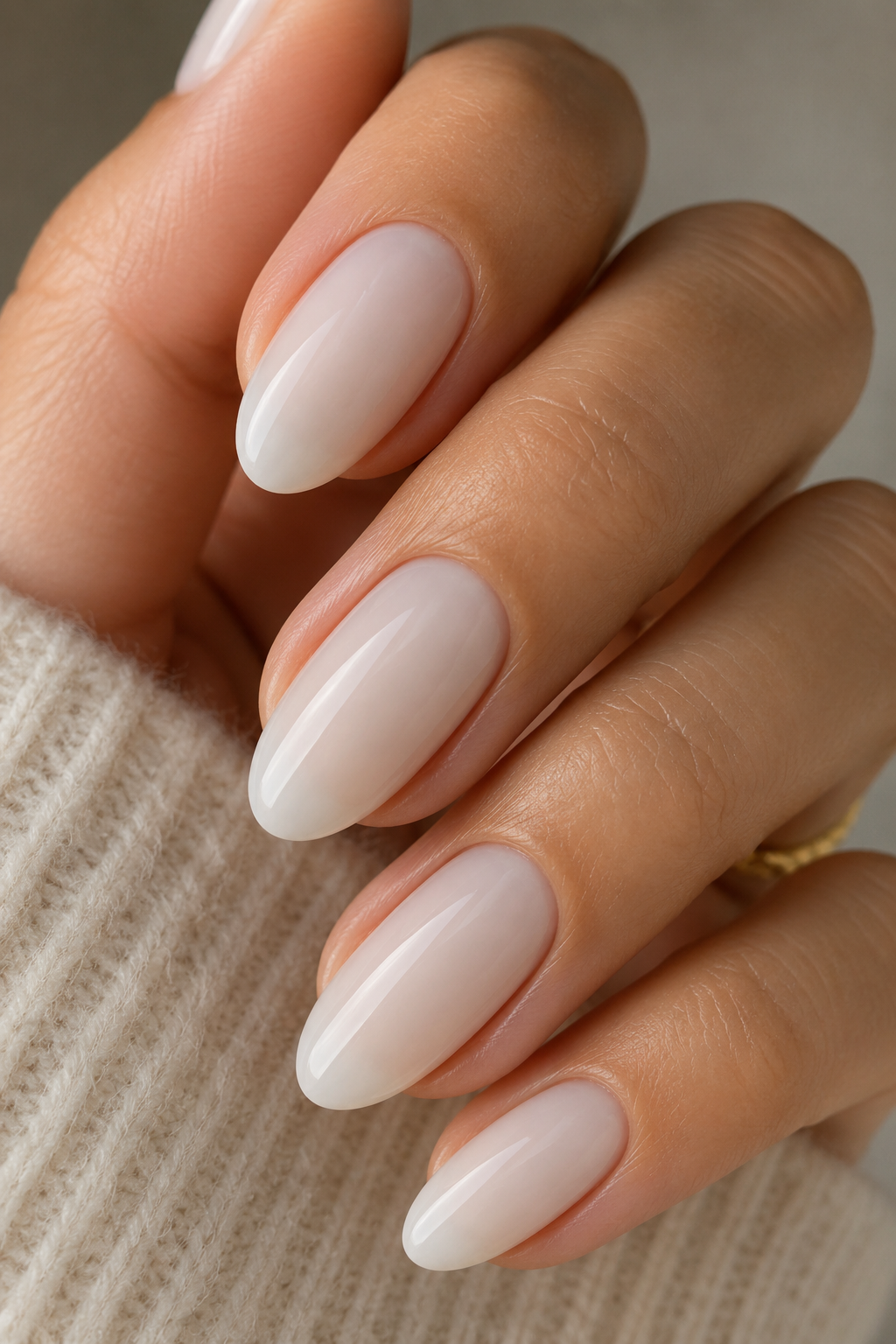 Cloud dancer nails in a sheer milky white finish on almond-shaped hands, styled for quiet luxury.