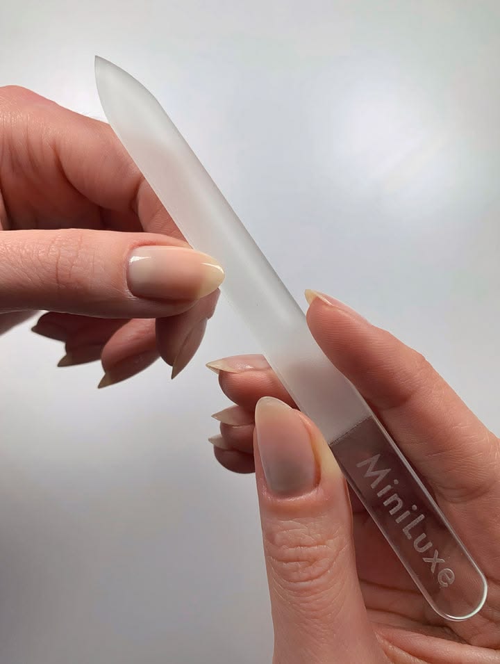 Using a glass nail file to shape short natural nails without causing additional damage