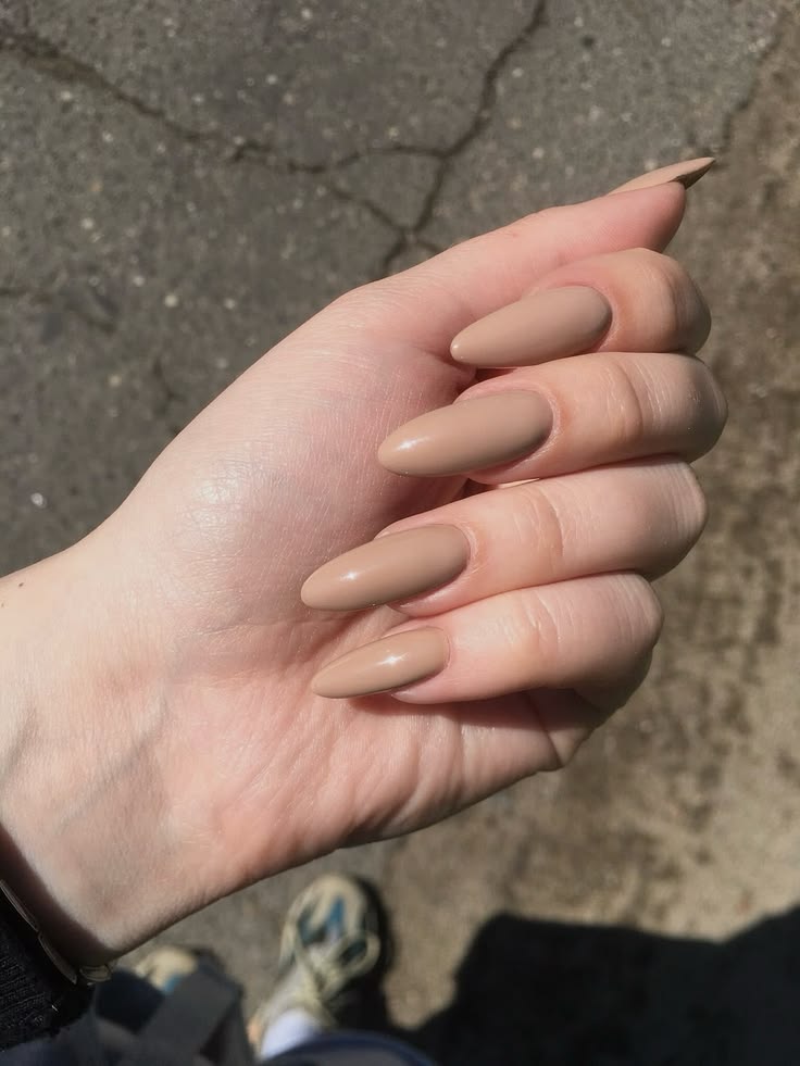Warm sand nude almond nails with a minimalist glossy finish creating a clean girl and quiet luxury aesthetic