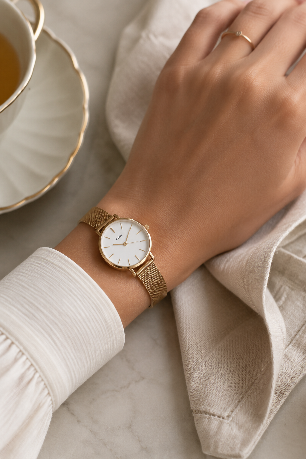 Slim gold watch paired with a manicured hand for a quiet luxury look